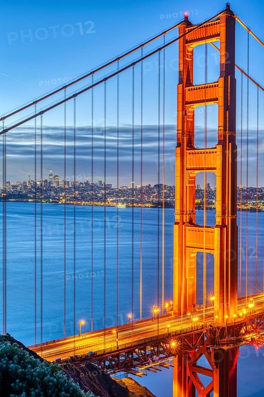Detail of the famous Golden Gate Bridge at dawn with the San Francisco skyline in the background