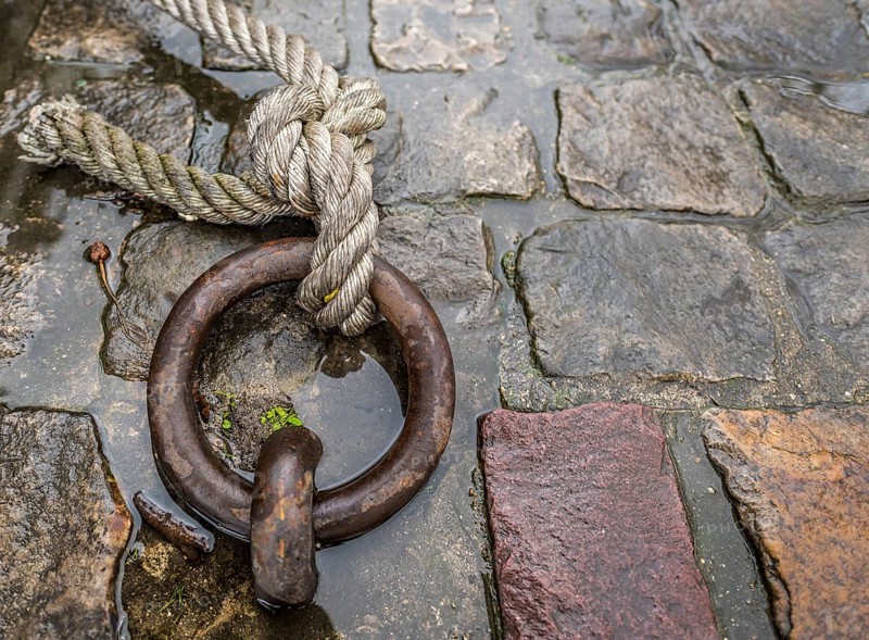 Close up image with a solid iron ring used to secure the anchoring of the ships on the docks, called mooring ring