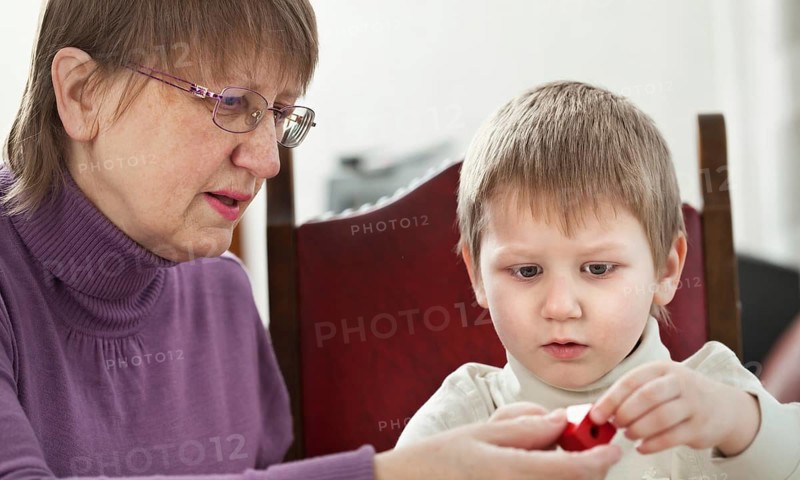 Granny is playing with her grandson at home, Belgium, Europe