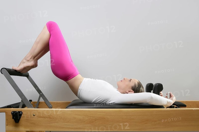 Pilates reformer woman gym fitness teacher legs exercise