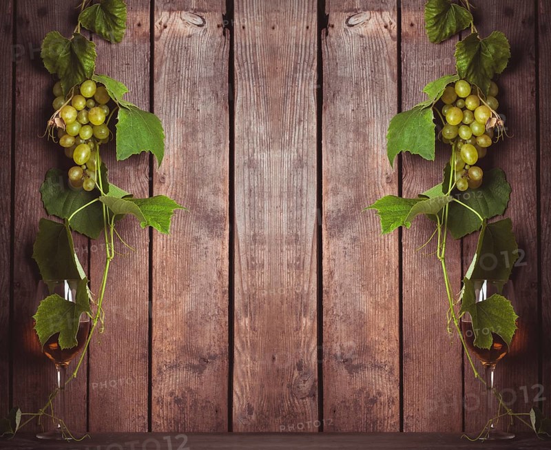 Grapes with leaves and glass of wine on the wood background