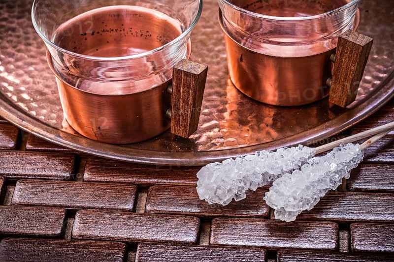 Close up view of coppery tray tea cups sugar sticks