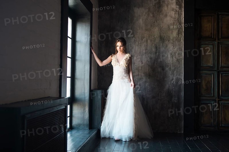 Portrait of beautiful young woman on dark background near the window