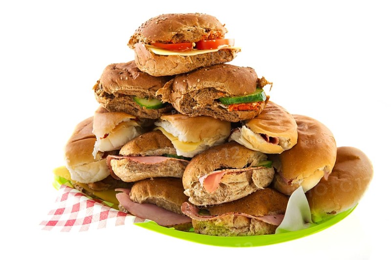 Many bread rolls with meats and cheese