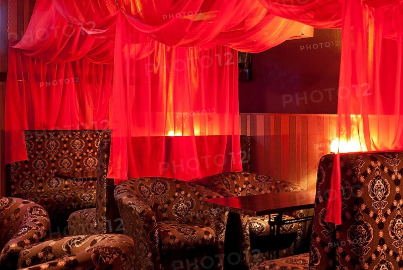 Restaurant interior (oriental style) - soft sofas and red transparent curtains