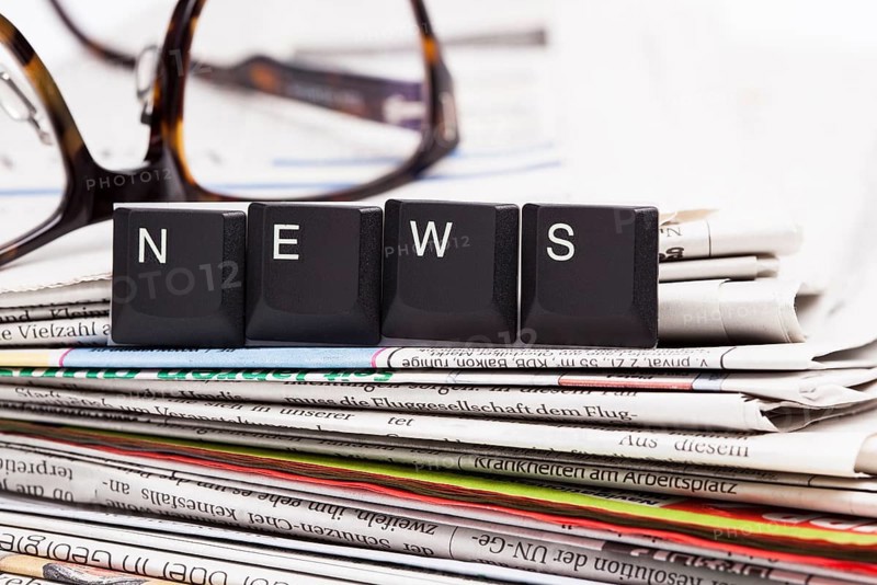 The image shows a stack of newspaper with set of letters