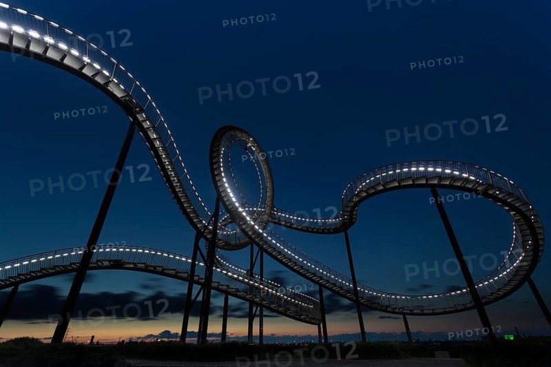 Roller coaster with illuminated design against the evening sky, Tiger and Turtle, Duisburg, North Rhine-Westphalia, Germany, Europe