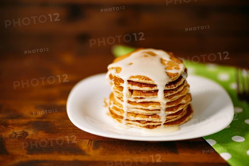 Condenced milk being poured on a stack of pancakes. High quality 4k footage