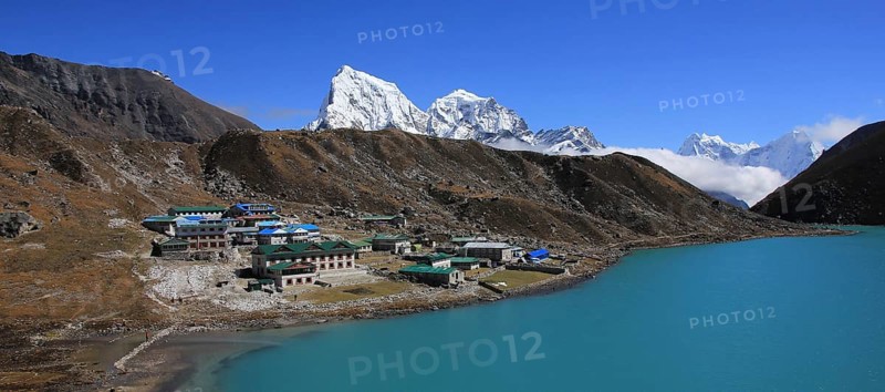 Lodges in Gokyo, turquoise lake and snow covered mountain Cholatse, Nepal, Asia