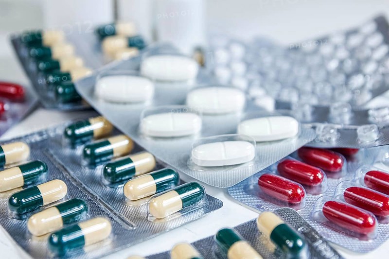 Assorted blister packs featuring a variety of pills and capsules in white and red
