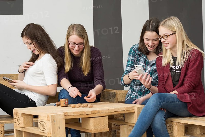Funny group of teenagers with their smartphones
