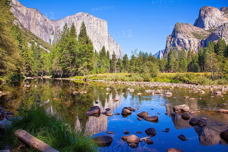 Beautiful day in the park valley. Yosemite Park is located on the slopes of the Sierra Nevada. Charming El Capitan and trees is reflected in the smooth water of little lake