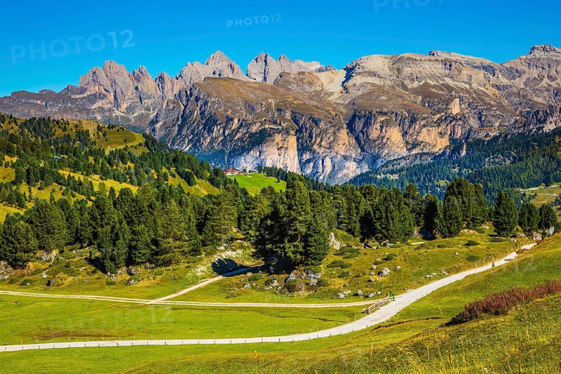 Windy sunny autumn day. Travel to South Tyrol, Dolomites. The concept of extreme and ecological tourism. The picturesque road on the Sella Pass