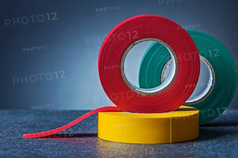 Multy colored rolls of insulation tape on gradient gray background