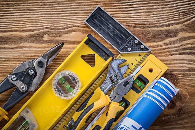 Composition of construction tools on vintage wooden board top view