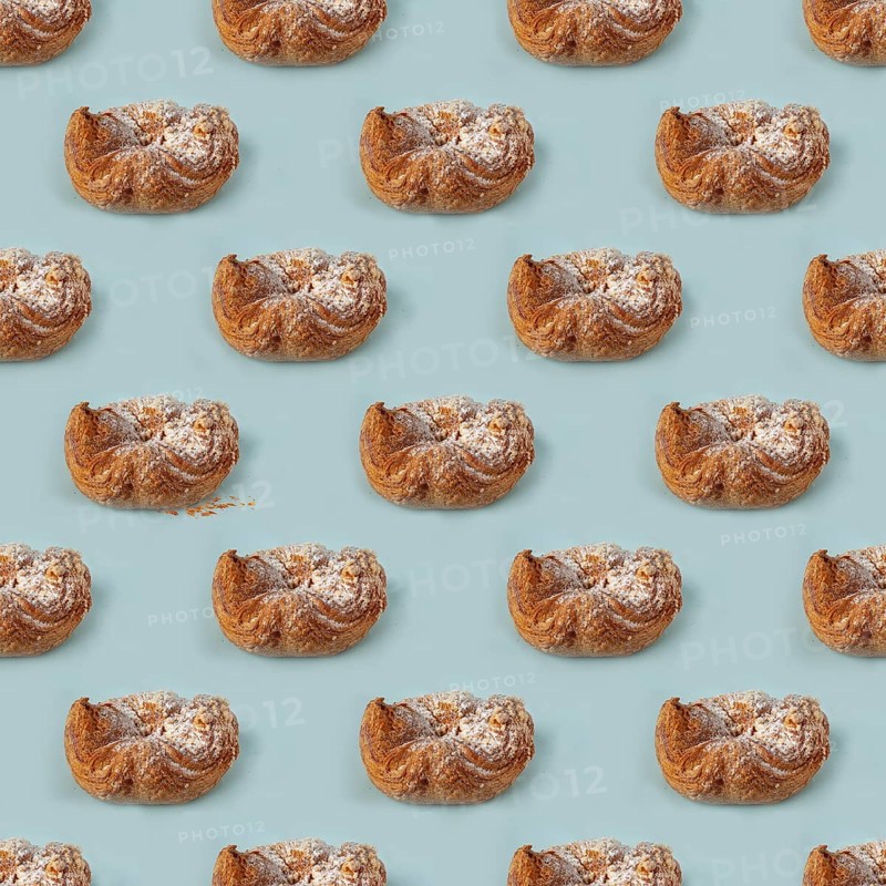Puff pastry buns of fancy shape, with crumbs, on a blue background, pattern