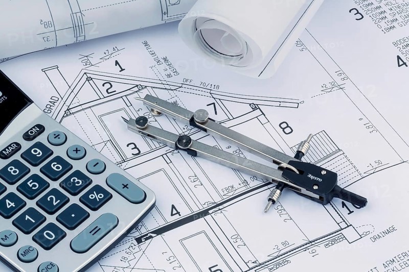 An architect's construction plan with a calculator. Symbolic photo for financing and planning a new house. Austria