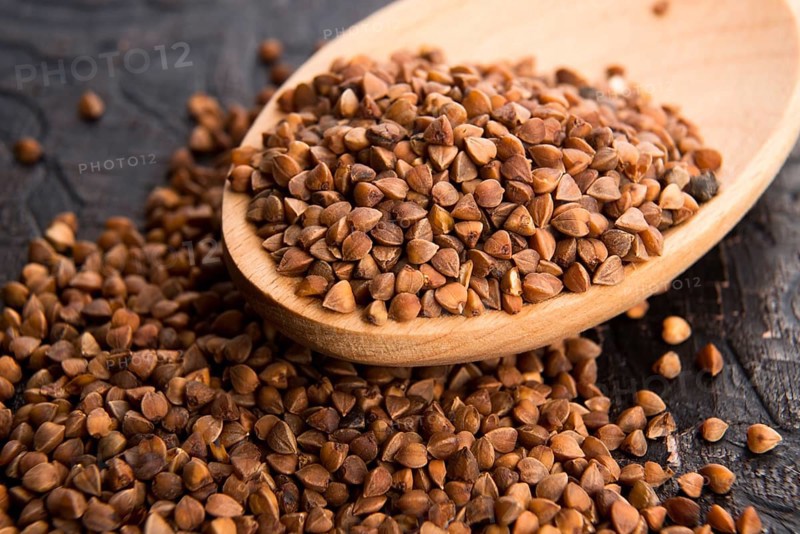 Buckwheat seeds on wooden spoon in closeup, lodz, poland