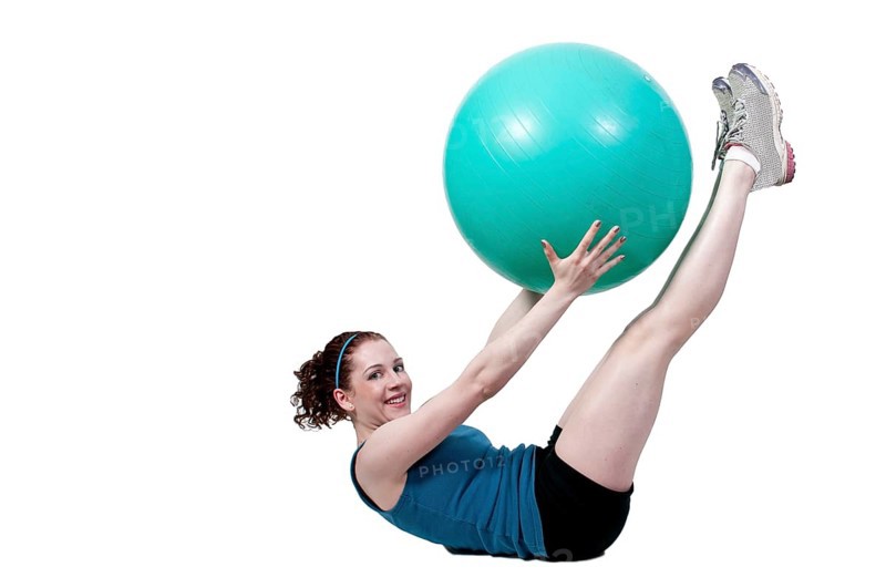 A beautiful young woman working with an aerobic exercise ball
