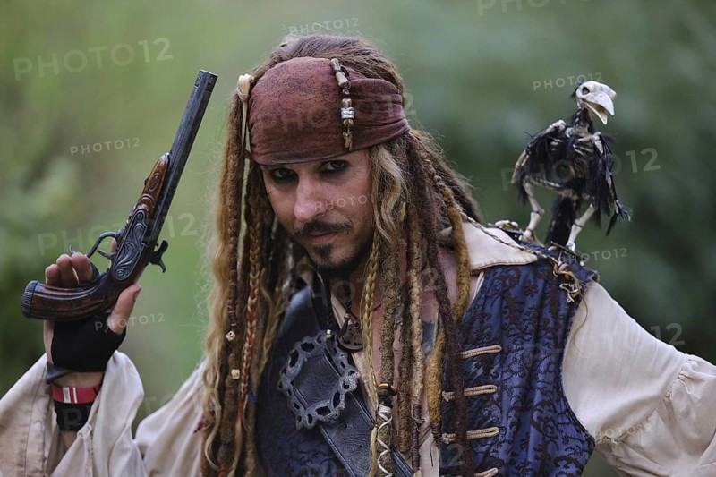 Man in pirate costume with bird on his shoulder
