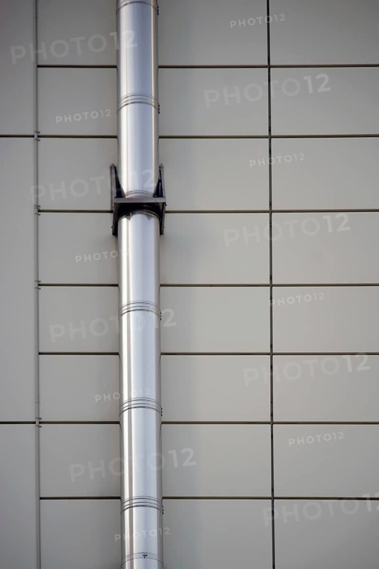 A mounted stainless steel pipe on a symmetrically arranged sheet metal façade