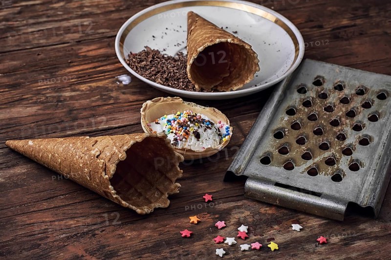 Ice cream decorated with sweet powder in the wafer on wooden background