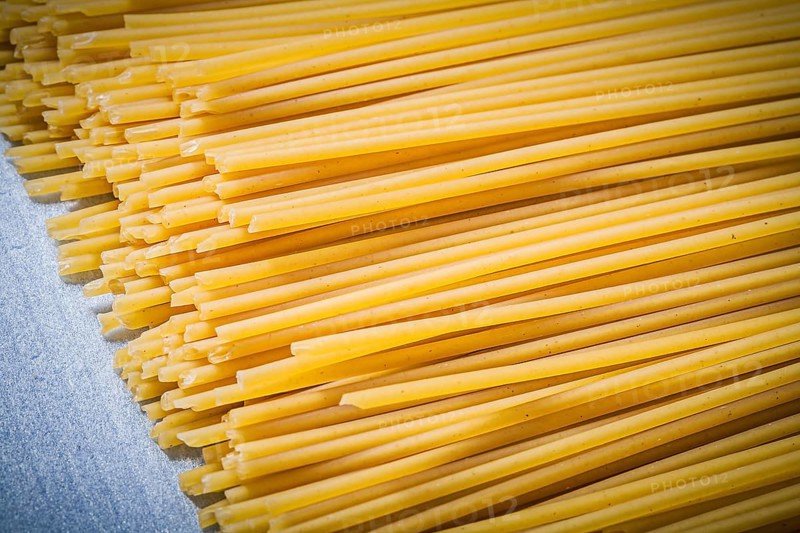 Heap of thin spaghetti on blue background directly above food and drink concept