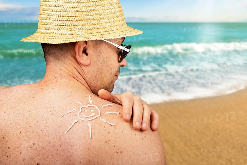 Middle aged caucasian male model applying sunscreen