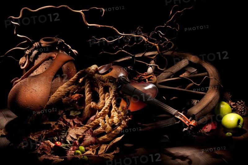Ceramic pots, old wheel and violin on a wooden table