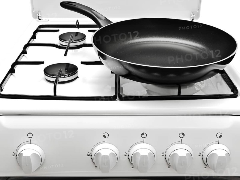 Frying Pan At The White Gas Stove Over The White Background