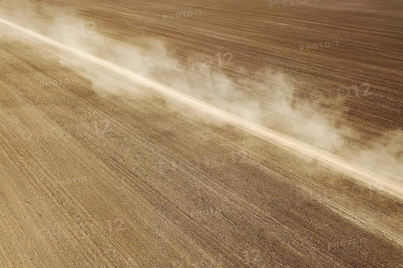 Aerial View Dirt road crossing Plowed Field