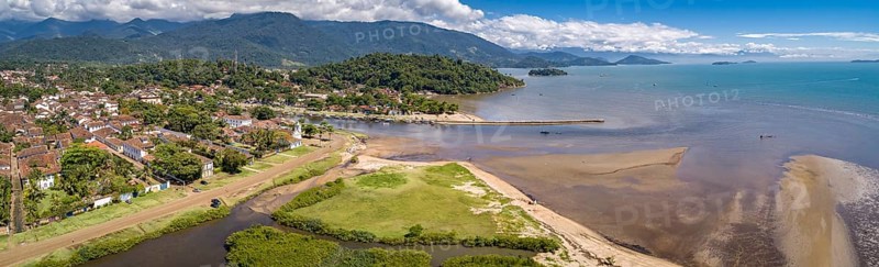 Panoramic aerial view to historic town Paraty, tidal river and Jabaquara with green mountains in background on a sunny day, Brazil, Unesco World Heritage, South America