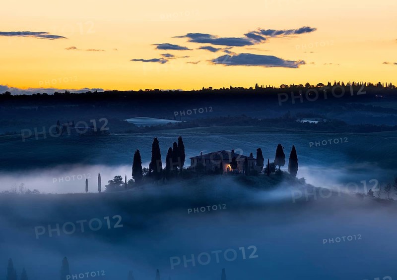 Tuscany farmhouse in morning mist with yellow skies, Val d'Orcia, Italy, Europe