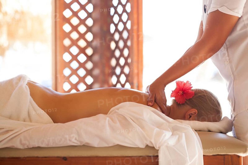 Woman getting professional back massage at beauty spa on resort. Health and body care