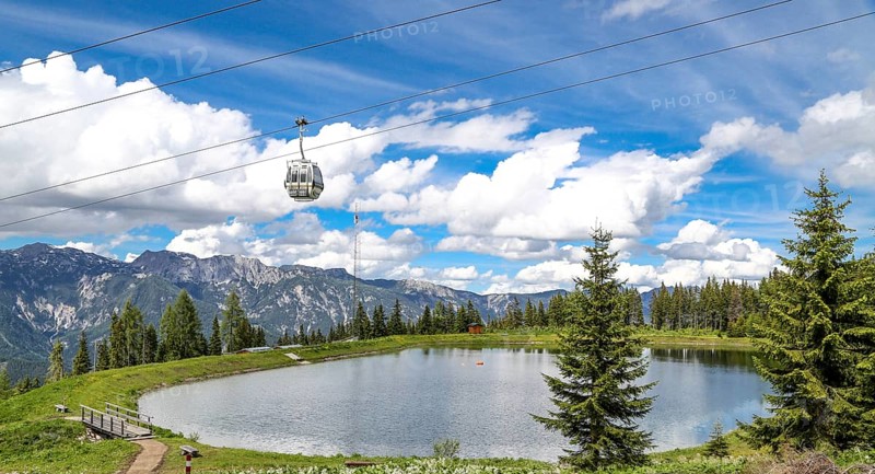 Small lake on the Planai with gondola lift. Smal water reservoir on a mountain by schladming, planai