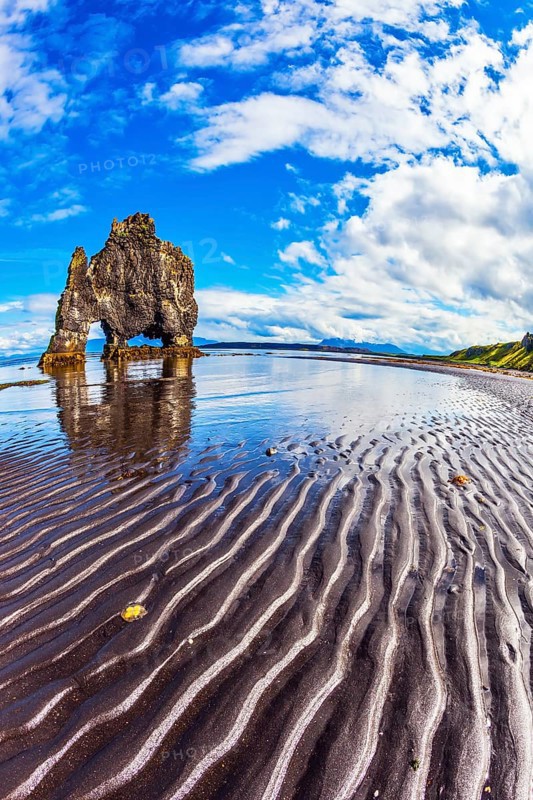 Rock Hvitserkur in the form of a huge mammoth on the sea beach. The north coast of Iceland. The concept of extreme northern tourism. Ocean tide at sunset