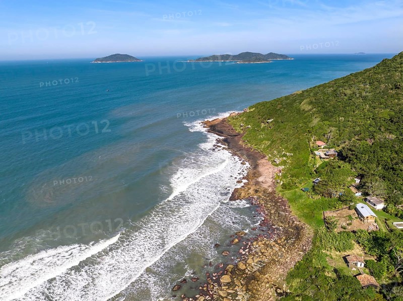 Coastline with beach, mountains and blue ocean with waves in Brazil. Aerial view of Saquinho beach. Florianopolis Santa Catarina. SC