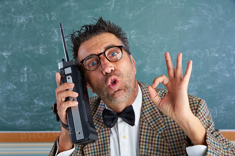 Nerd silly private investigator with retro walkie talkie on teacher balckboard