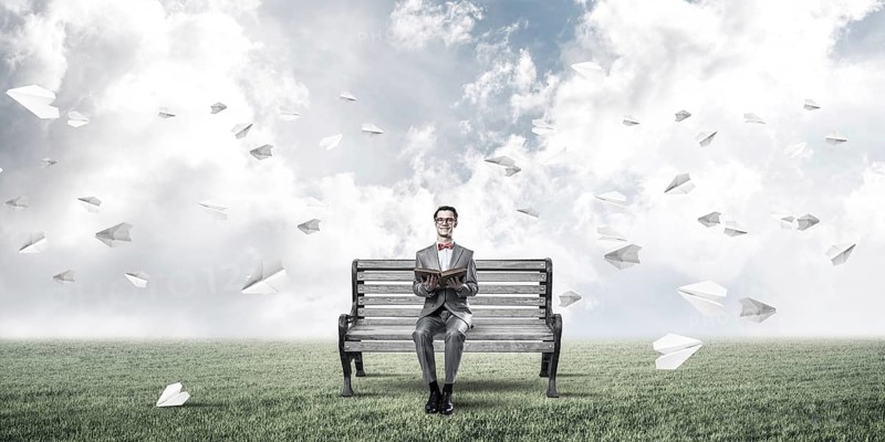 Young businessman or student studying the science and paper planes fly around