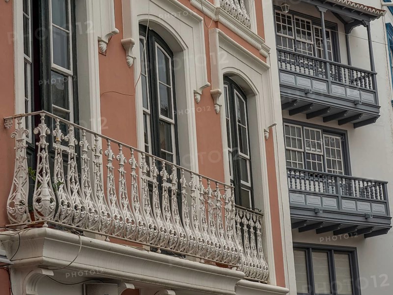 Detailed view of an old building façade with ornate balconies and windows. The colours are muted, la palma, canary islands, spain
