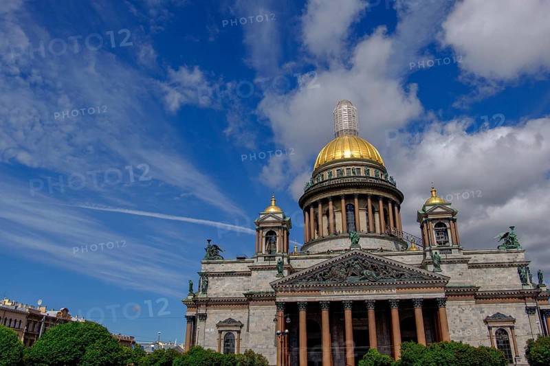 Building with golden dome under blue sky with clouds and trees in the foreground, saint petersburg, baltic sea, russia