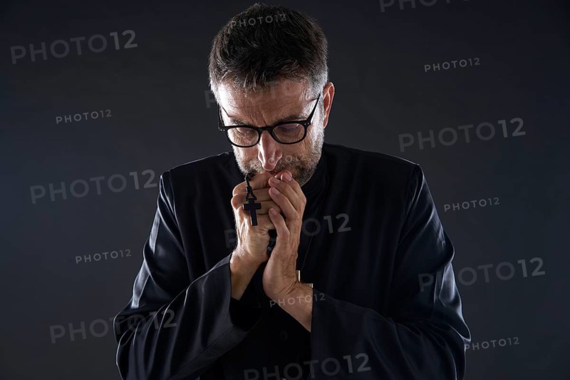 Priest praying hands with rosary beads male