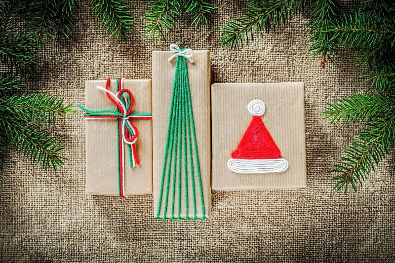 Set of fir tree branches handmade gift boxes on burlap background