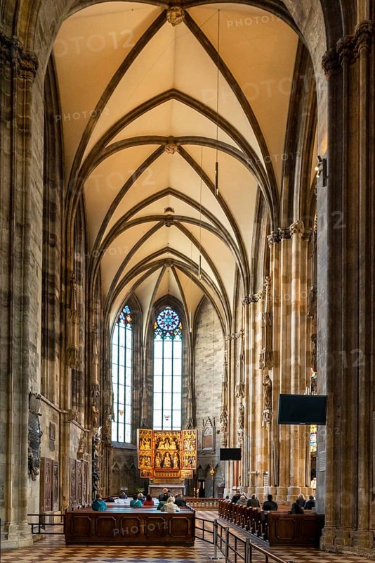 Vienna, Austria, 22 September, 2022: people praying during a church service in one of the side chapels of the historic St. Stephen's Cathedral in Vienna, Europe