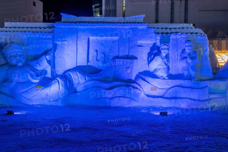 Taebeck, South Korea. January 29, 2019: Large snow sculpture depicting people in front of castle wall on display downtown during winter festival
