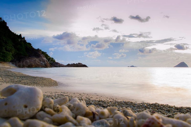 Peaceful and tropical coral turtle beach at Perhentian Islands, Malaysia, long exposure, with cloudy sky during sunset. Postcard, mural or wallpaper about Malaysian tourism or travel, Asia