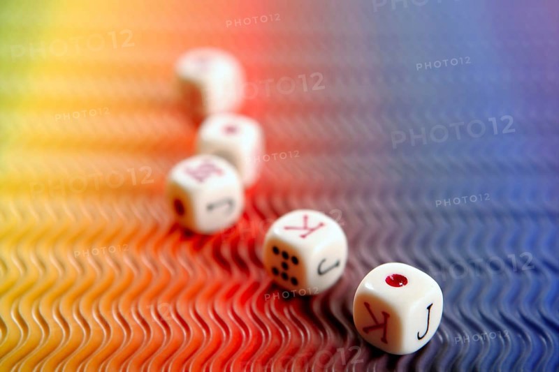 Poker dices over colored background, selective focus