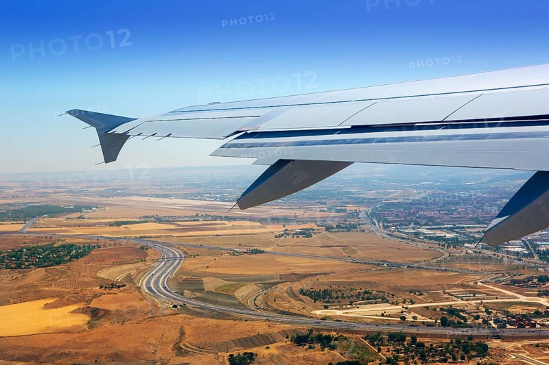 Airplane takeoff from Madrid Barajas over golden wheat fields