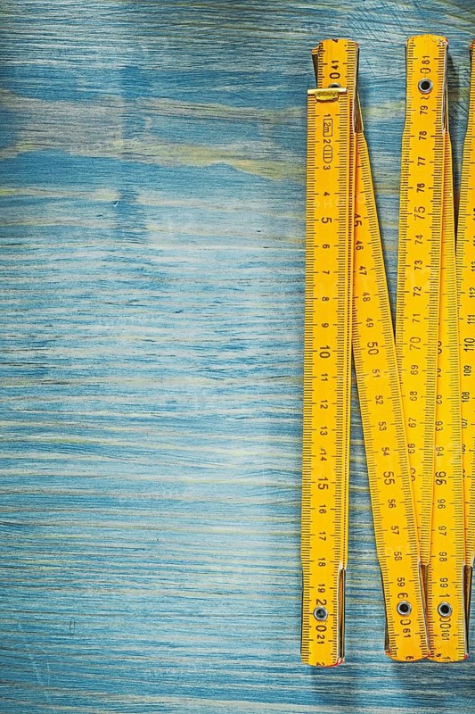 Yellow wooden meter on vintage wood surface construction concept