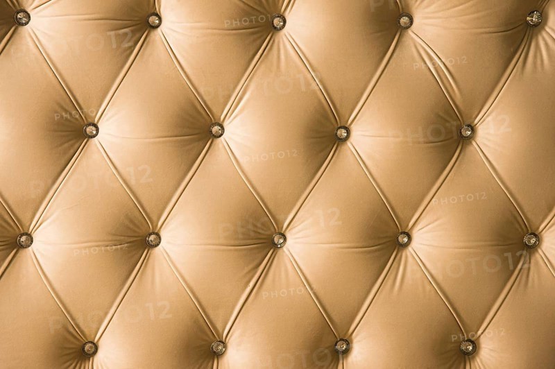 Beige soft textile background with symmetrical buttons on the corners of diamonds. Soft and expensive furniture elements. Luxury background